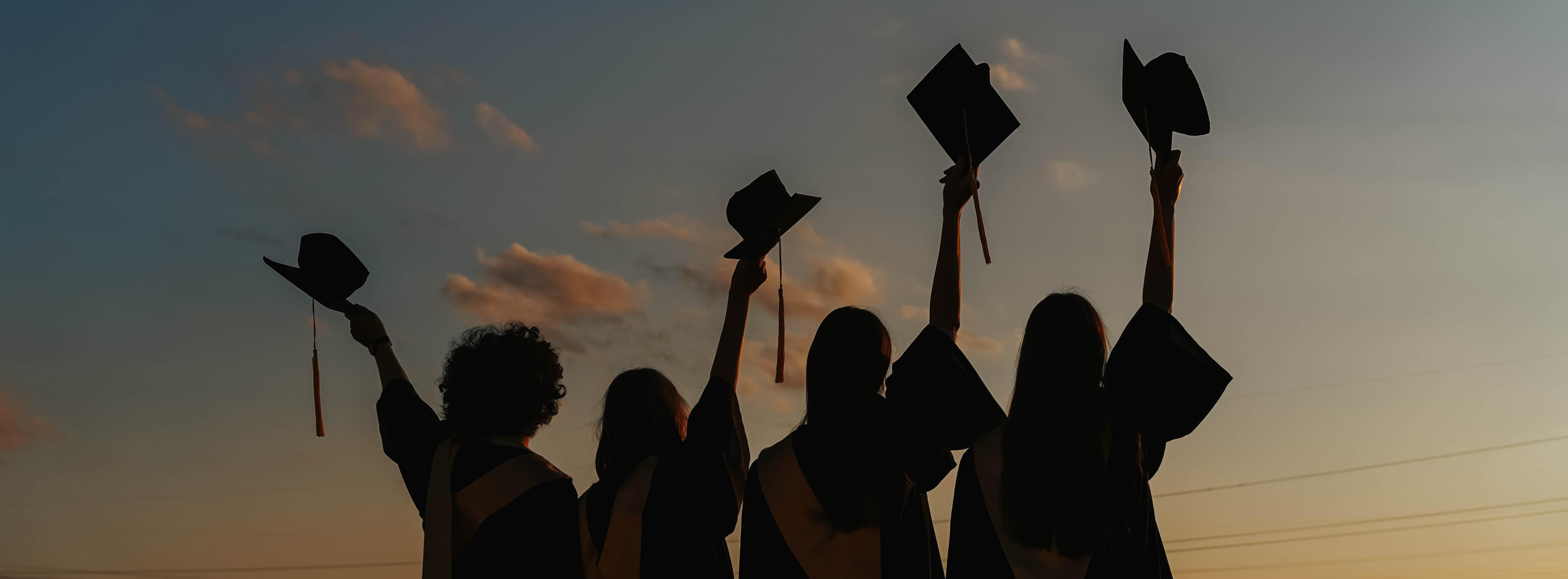 Silhouette of People Raising Their Graduation Hats