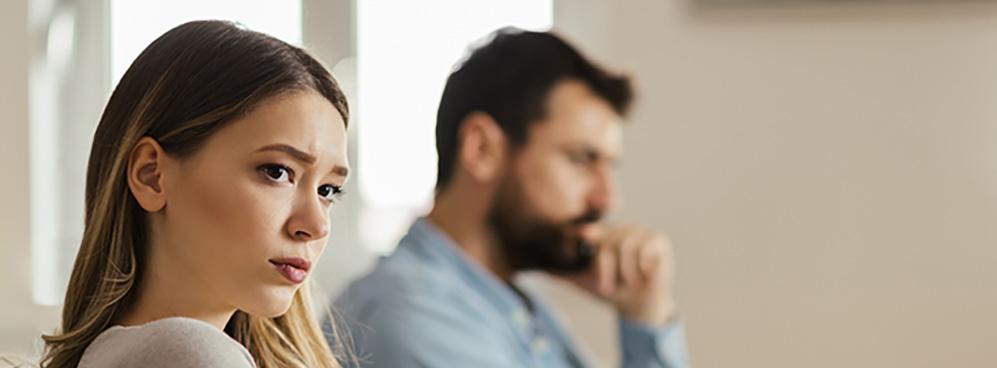 Worried couple sitting on sofa