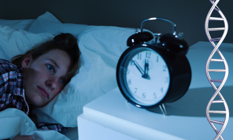 Woman struggling to sleep, looking at alarm clock