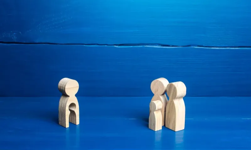 Family as wooden figures against blue background
