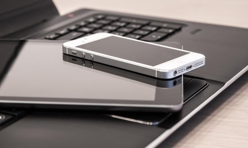 Laptop, iPad and phone stacked on a desk