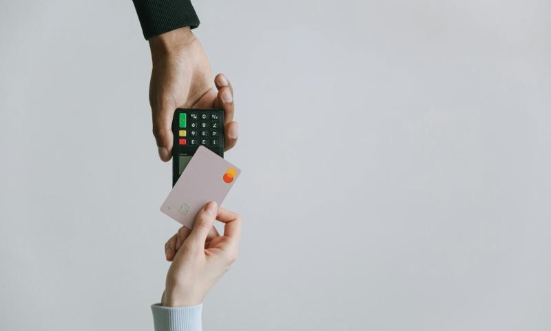 Person making a contactless payment between a credit card and card machine