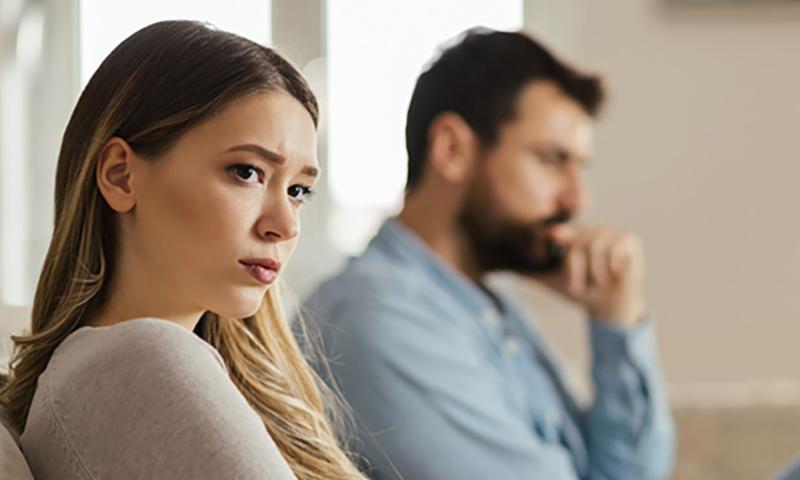 Worried couple sitting on sofa